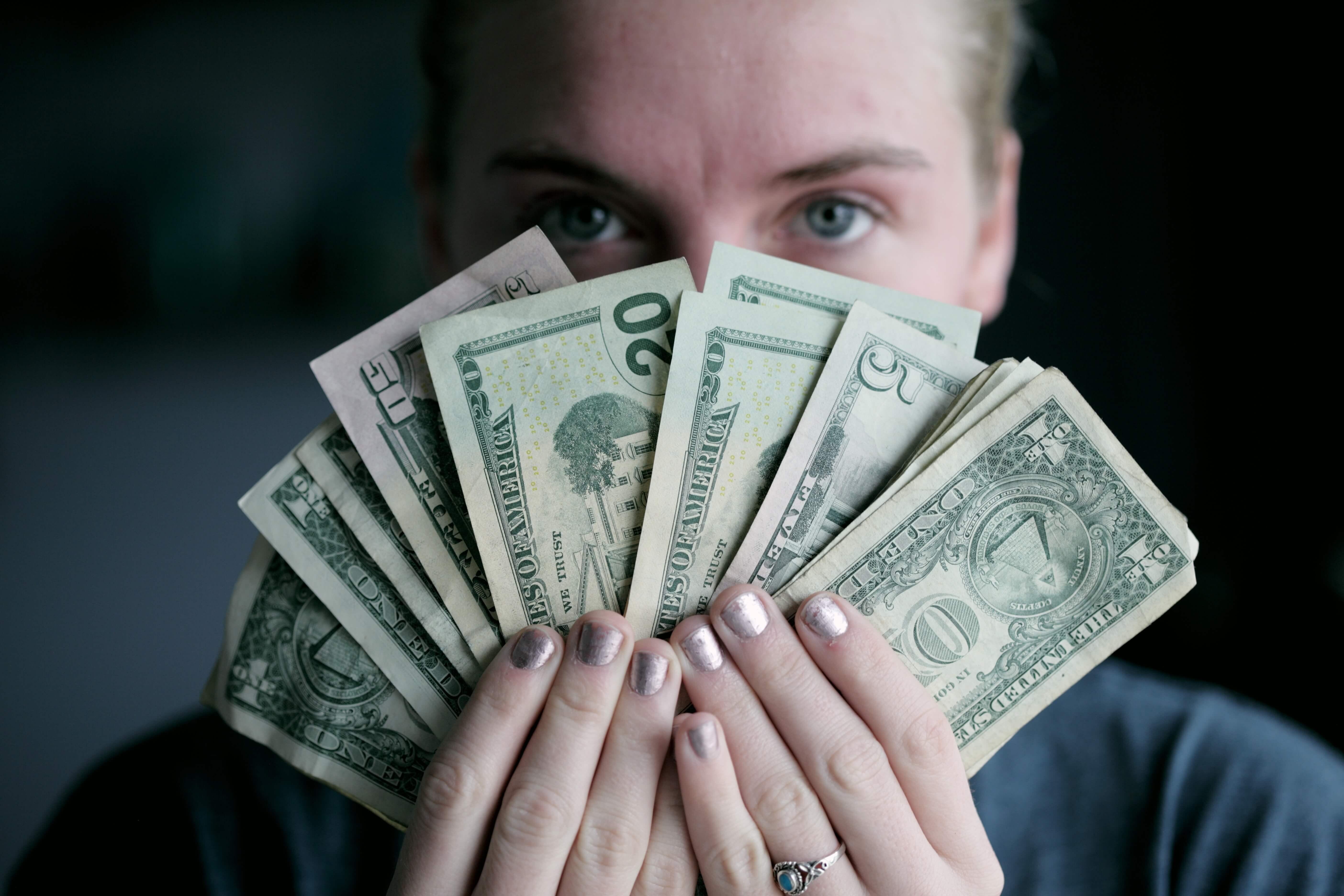 Young woman holding money.