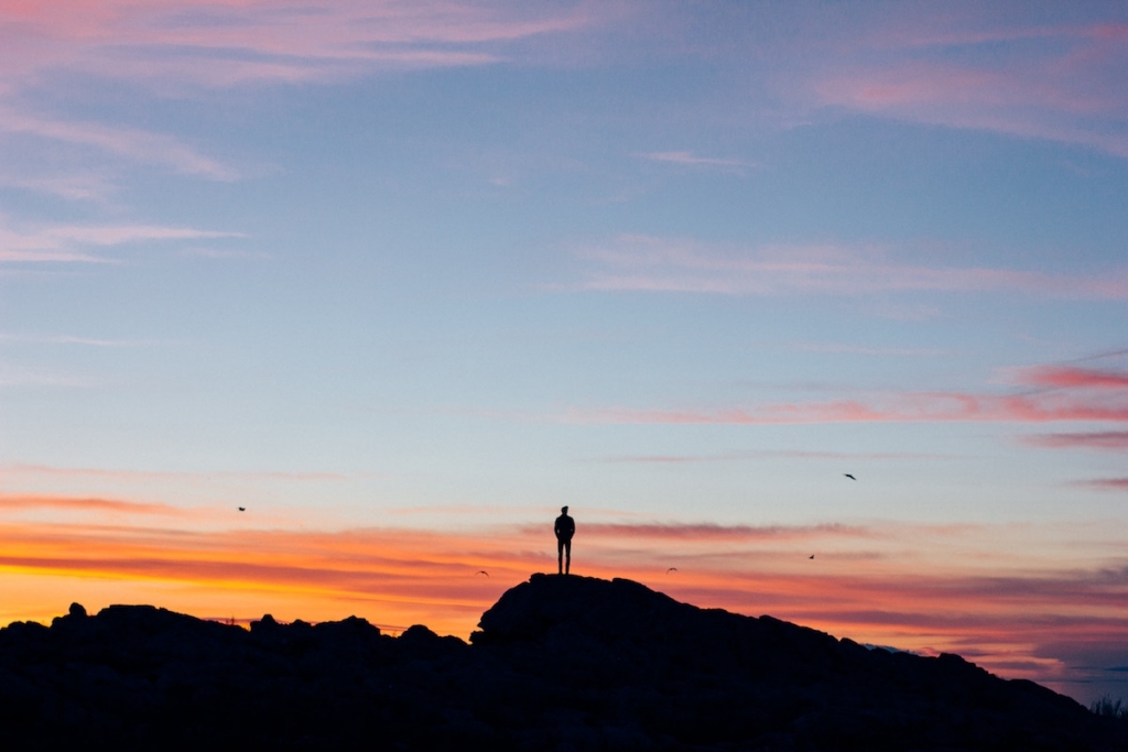 Man alone on mountain at sunset