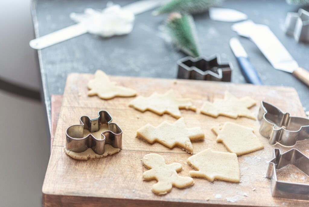 christmas cookie cut-outs on a cutting board, specifically sugar cookies