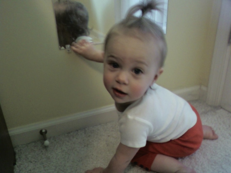 My daughter at one year old staring back at me with a little pigtail in her hair