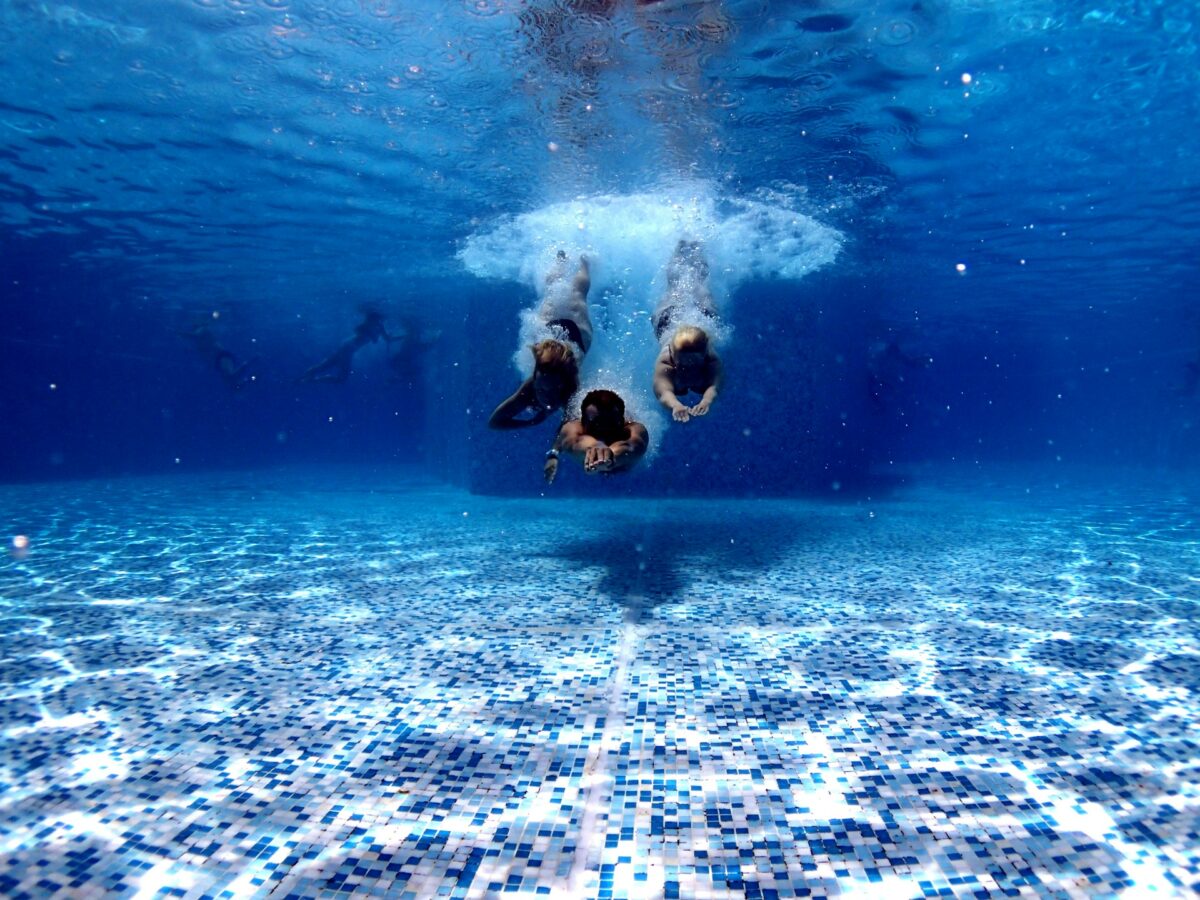 kids diving into the water of a swimming pool